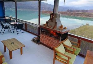 a fireplace on a balcony with a view of a lake at SuperPanorama GuestHouse in Kukës