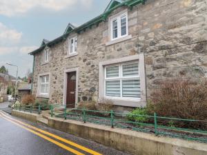 a stone house on the side of a street at Pirnies in Pitlochry