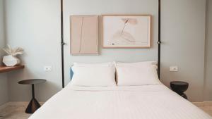 a bedroom with a white bed with two pillows at TPH Rooms in Taormina +28 photos