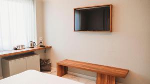 a flat screen tv on the wall of a bedroom at TPH Rooms in Taormina