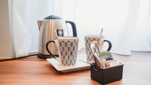 two coffee cups on a table next to a coffee maker at TPH Rooms in Taormina