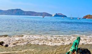 a person laying on the beach near the water at Tuya Casita in Zihuatanejo
