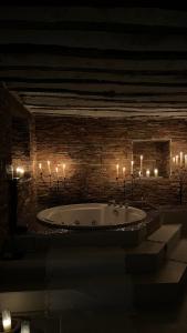 a bath tub in a room with lit candles at Hotel La Casa del Canónigo in Caracenilla +72 photos
