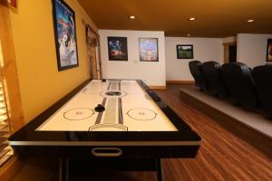 a ping pong table in a room with chairs at Firefly Nights – 5-Bed Mountain Chalet with Private Theater and Elevator in Gatlinburg +60 photos