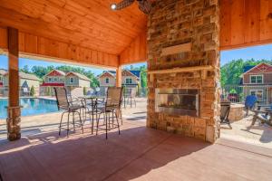 a patio with a fireplace and a table and chairs at Luxury Chalet w Indoor Pool, Theater Room & Game Loft — 4 Miles to Gatlinburg in Gatlinburg