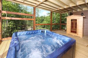a hot tub on the deck of a cabin at Luxury Chalet w Indoor Pool, Theater Room & Game Loft — 4 Miles to Gatlinburg in Gatlinburg