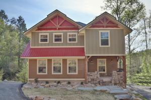 a house with a red roof at Luxury Chalet w Indoor Pool, Theater Room & Game Loft — 4 Miles to Gatlinburg in Gatlinburg