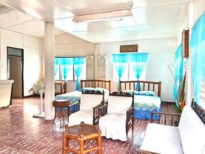 a bedroom with two beds and blue curtains at Tamari's Rest House in Lian