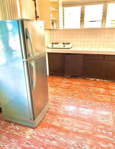 a stainless steel refrigerator sitting in a kitchen at Tamari's Rest House in Lian +2 photos