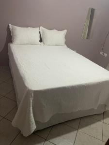 a large white bed with white sheets and pillows at Lareconexao in Foz do Iguaçu