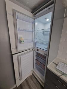 an empty refrigerator with its door open in a room at Cloverdale in Bedlington
