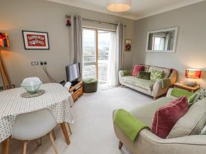 a living room with a table and a couch at Cuddy's Holm in Seahouses