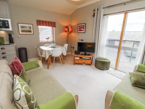 a living room with a couch and a table at Cuddy's Holm in Seahouses