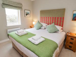a bedroom with a large bed with towels on it at Cuddy's Holm in Seahouses