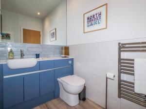 a blue bathroom with a toilet and a sink at Cuddy's Holm in Seahouses +31 photos