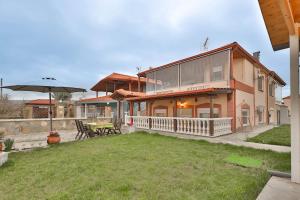 a large house with a patio and a yard at Villa Lydia Kariani in Karianí