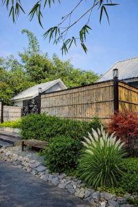 a wooden fence with a bench in a garden at Na Ville Resort in Ban Huai Yai