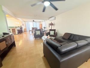 a living room with a black leather couch and chairs at Casa Sol-Oasis del Mar in Progreso