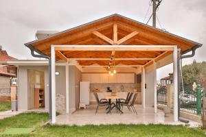a pavilion with a table and chairs on a patio at Villa Lydia Kariani in Karianí