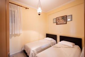 two beds in a room with a window at Villa Lydia Kariani in Karianí