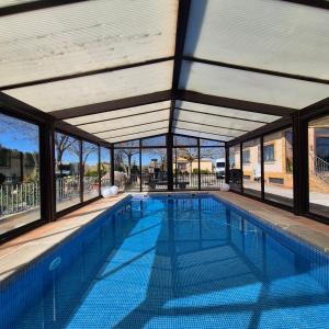 an empty swimming pool with glass walls and a large building at Finca Don Sancho by Mayne in Lillo