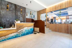 a lobby with a large wave painting on the wall at Hotel Cala Arena in San José