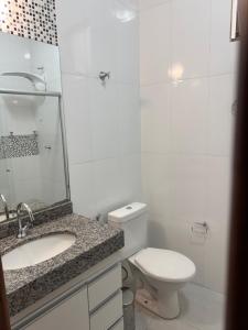 a bathroom with a toilet and a sink and a mirror at Casa da Glória 1 in Diamantina +16 photos