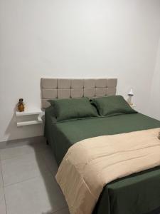 a bedroom with a large bed with green sheets at Casa da Glória 1 in Diamantina
