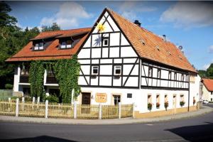 a black and white building with a red roof at Gästehaus Stadtschaenke in Liebstadt