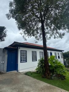 a house with a blue door and a tree at Casa da Glória 1 in Diamantina