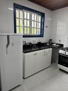 a kitchen with white cabinets and a sink and a window at Casa da Glória 1 in Diamantina