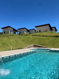 a swimming pool in front of some houses at Pousada Varandas de Minas in Monte Verde