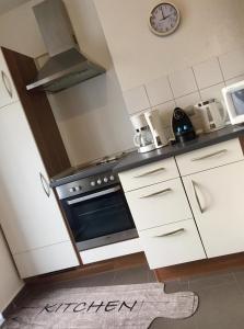 a kitchen with a stove and a clock on the wall at Apartment H50 in Hannover