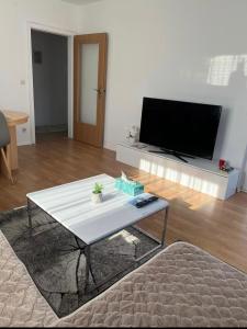 a living room with a white table and a tv at Ferienwohnung in Bad Honnef in Bad Honnef am Rhein