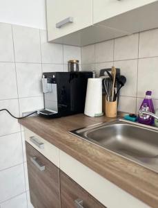 a kitchen counter with a sink and a microwave at Ferienwohnung in Bad Honnef in Bad Honnef am Rhein +6 photos