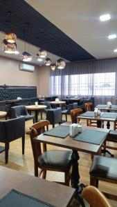 a dining room with tables and chairs and windows at Hotel Mirage in Vilhena