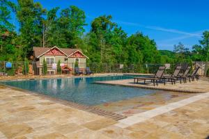 a swimming pool with chairs and a house at Break Time - Modern 5BR with hot tub, game room, air hockey and resort pool in Gatlinburg