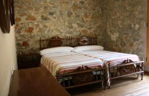 a bedroom with two beds and a wooden table at Complejo Turístico Fuenmayor in Torres