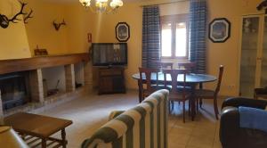 a living room with a fireplace and a table and a tv at Complejo Turístico Fuenmayor in Torres