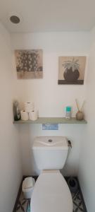 a bathroom with a toilet with two pictures on the wall at Gîte de la Fecleval 6 personnes proche puy dufou in Saint-Mesmin +24 photos