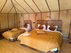 a bedroom with two beds in a tent at Milagro Luxury Camps in Merzouga