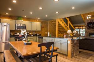 a large kitchen with a wooden table and a kitchen with a tableablish at Gatlinburg Pool Pad – Luxury 4BR Chalet, Indoor Pool, Sauna & Theater Room in Gatlinburg