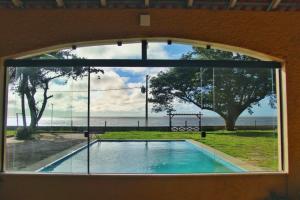a window with a view of a swimming pool at Pousada Marajo in Salvaterra