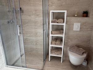 a bathroom with a shower and a toilet and towels at Apartments Verde in Lumbarda +18 photos