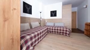 a bedroom with a bed with a plaid blanket at Plagheira 1 in Santa Caterina Valfurva +6 photos