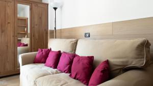 a couch with purple pillows on it in a room at Plagheira 1 in Santa Caterina Valfurva