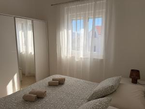 a white bedroom with a bed with two pillows on it at Apartments Verde in Lumbarda