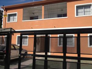 a fence in front of a building with a car at Apart Orange in Pilar