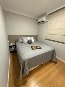 a bedroom with a bed with a tray of food on it at Carvalho Home in Londrina
