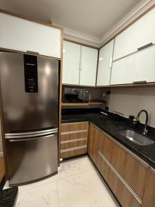 a kitchen with a stainless steel refrigerator and a sink at Carvalho Home in Londrina
